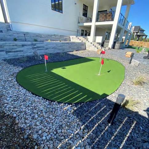 Backyard putting green set into paver paths and planting
